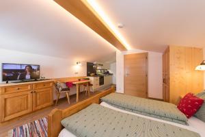 瓦尔赫湖Hagerhof的一间卧室配有一张床,并在一间客房内配有电视。
