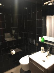 蓬塔德尔加达Thomas Place的黑色瓷砖浴室设有卫生间和水槽