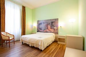 蒙特卡蒂尼泰尔梅巴尔托利尼智能酒店的卧室配有一张床,墙上挂有绘画作品
