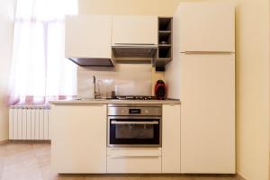 圣雷莫ROSA CENTRALISSIMO的白色的厨房配有炉灶和冰箱。
