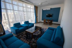 马斯喀特Home Station Hotel的客厅配有蓝色的沙发和桌子