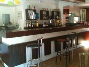 Luzenac拉派克斯酒店的吧台上设有四把凳子的酒吧
