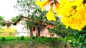 库尼亚Pousada Colar de Ouro的前面有黄色花的房子
