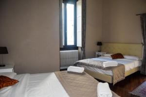 佛罗伦萨索奇奥诺卡普拉旅馆的一间卧室设有两张床和窗户。