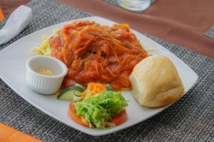 比加瓜Heliconias Rainforest Lodge的盘子的食物,包括面食和蔬菜以及三明治