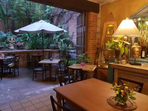 莫雷利亚Casa Embrujo Morelia - Boutique的一间带桌椅和遮阳伞的餐厅