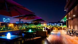 上海古凡酒店的屋顶庭院在晚上提供桌子和遮阳伞