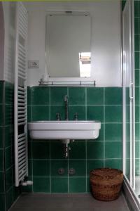 圣费利切德尔贝纳科Punta Del Corno Agriturismo的绿色瓷砖浴室设有水槽和镜子