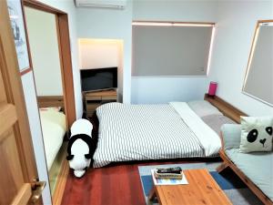 冈山冈山熊猫度假屋的一间卧室,里面设有床和狗
