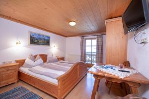 平茨高谷地霍勒尔斯巴赫Peilberghof的一间卧室配有一张大床和一张木桌