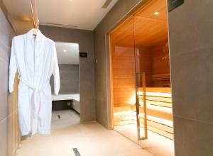 里乔内德拉威乐酒店的挂在浴室内的浴袍,浴室内设有步入式淋浴间