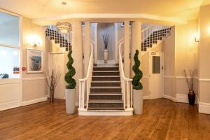 基督城Sandhills Apartments, Mudeford的白色柱子和绿色植物间的楼梯
