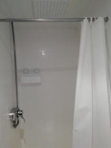 布莱克浦彭林旅馆的配有白色淋浴帘和淋浴头的淋浴