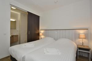斯希蒙尼克奥赫品质住宿酒店的卧室配有一张白色大床和两条毛巾