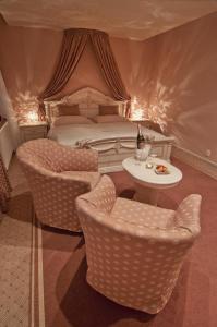 皮塞克白玫瑰大酒店的卧室配有一张床和一张桌子及椅子