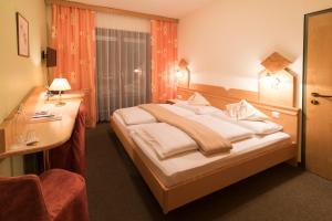 巴特布莱贝格维特柏格布雷博格酒店的配有一张床和一张书桌的酒店客房