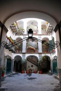 那不勒斯Casa Matys的一座有盆栽和灯的建筑中的拱门