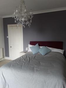 布里德波特Town House Bridport Dorset的一间卧室配有一张带吊灯的大床