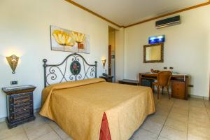 兰佩杜萨伊尔法洛德拉贵加托玛西诺酒店的一间卧室配有一张床、一张桌子和一张桌子