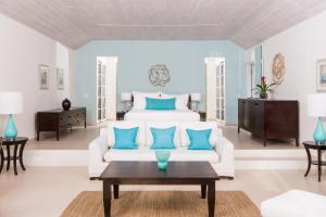 Old Road卡莱尔湾酒店的客厅配有白色的床和蓝色枕头。