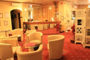 里昂富驰酒店的一间设有白色椅子、桌子和柜台的房间