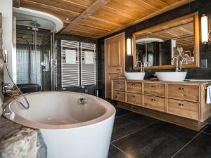 翁根舍内格酒店的大型浴室设有两个盥洗盆和浴缸。