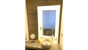 萨拉曼卡托莱克拉维洛公寓的一间带白色卫生间的浴室和窗户。