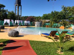伊瓜苏港Z Hotel Boutique的一个带两把椅子的游泳池和一个喷泉
