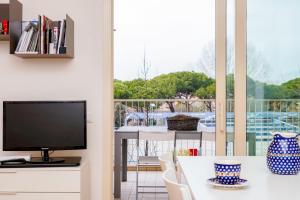 里米尼Appartamento Il Castello的客厅配有电视和桌椅