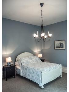 锡姆科卡韦德尼旅馆的一间卧室配有一张床和一个吊灯