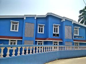 巴加Bijou Guest House的前面有栅栏的蓝色建筑