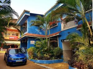 巴加Bijou Guest House的蓝色的建筑,前面有停车位