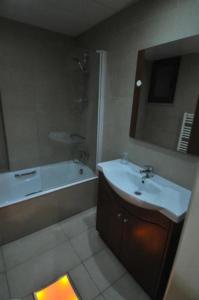 拉纳卡Ithaki Phinikoudes Apartment No. 205的浴室配有水槽、淋浴和浴缸。