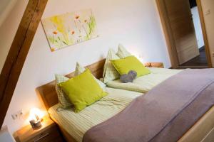 NeuhausWaldhof Grasel的一间卧室配有一张带绿色枕头的床
