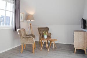 普雷罗Haus Sommerliebe的一间设有两把椅子、一张桌子和一盏灯的房间