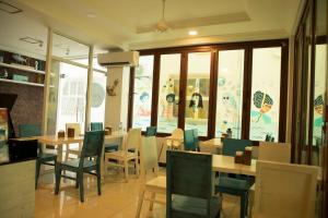 胡鲁马累Huvan Beach Hotel at Hulhumale的用餐室设有桌椅和窗户。