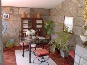 维亚纳堡Casa da Reina的配有桌椅和石墙的房间