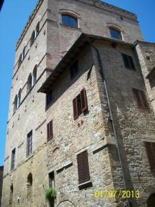 圣吉米纳诺La Torre Nomipesciolini的一座高大的砖砌建筑,设有窗户和塔