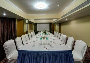 孟买瑞梅哈尔南酒店的一间会议室,配有长桌和白色椅子