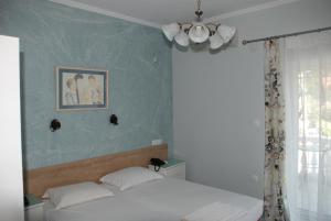 沃尔沃罗Diaporos Hotel的卧室配有一张床,墙上挂着一幅画
