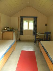 艾菲约德埃德福德海特度假屋的一间设有两张床的房间和红色地毯