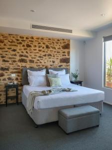 林道巴罗莎设拉子酒店的一间卧室设有一张带砖墙的大床