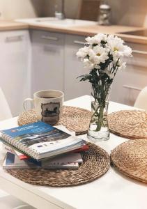 皮什Apartament Siódemka的桌子,桌子,书,花瓶,咖啡
