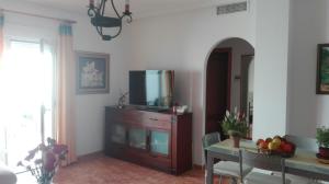 卡沃内拉斯Apartamento turístico en C/ Los Barquicos的客厅配有梳妆台顶部的电视