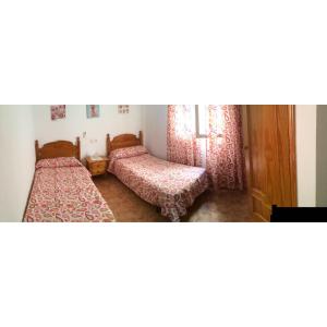 卡沃内拉斯Apartamento turístico en C/ Los Barquicos的客房设有两张床和窗户。