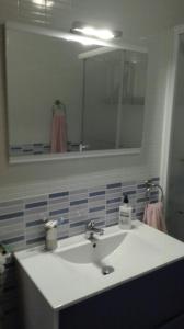卡沃内拉斯Apartamento turístico en C/ Los Barquicos的浴室设有白色水槽和镜子