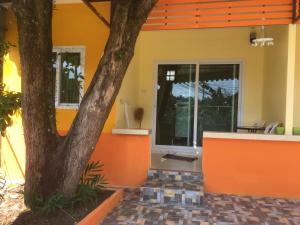 卡图卡图沃富度假屋的一座橘色房子,前面有一棵树