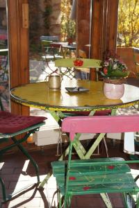 于伯林根Naturata Hotel的一张桌子、两把椅子和一张桌子,上面有鲜花