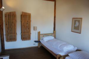 于伯林根Naturata Hotel的一间卧室设有两张床,墙上设有一面镜子