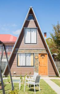 瓦尔迪维亚Pyramidal Park Valdivia的一个带两把椅子的 ⁇ 屋顶的房子
